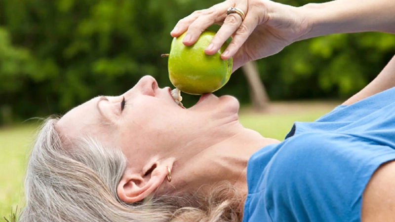 Frau beisst in einen Apfel