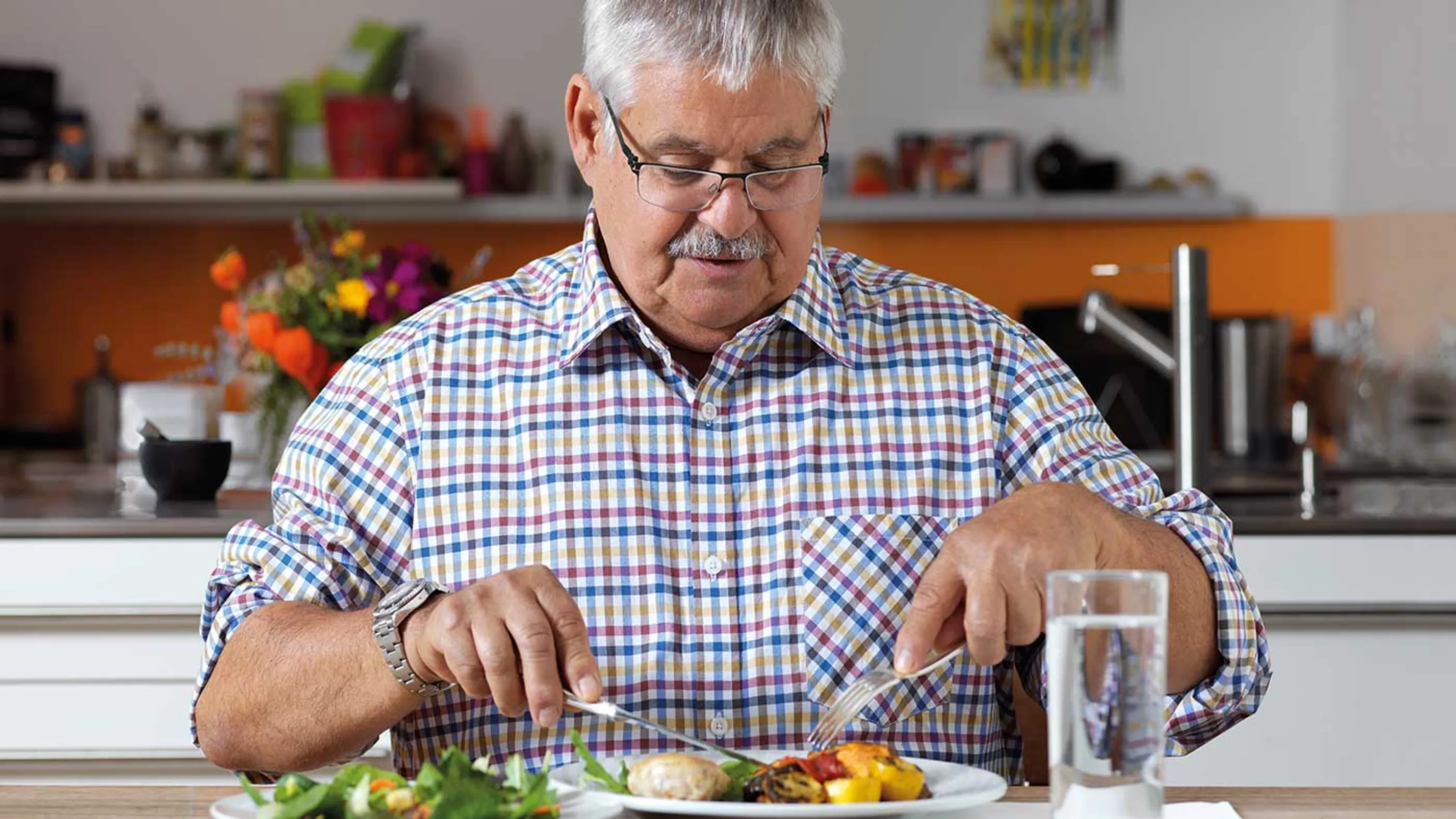 Ein Senior geniesst das Essen des Mahlzeitendiensts.