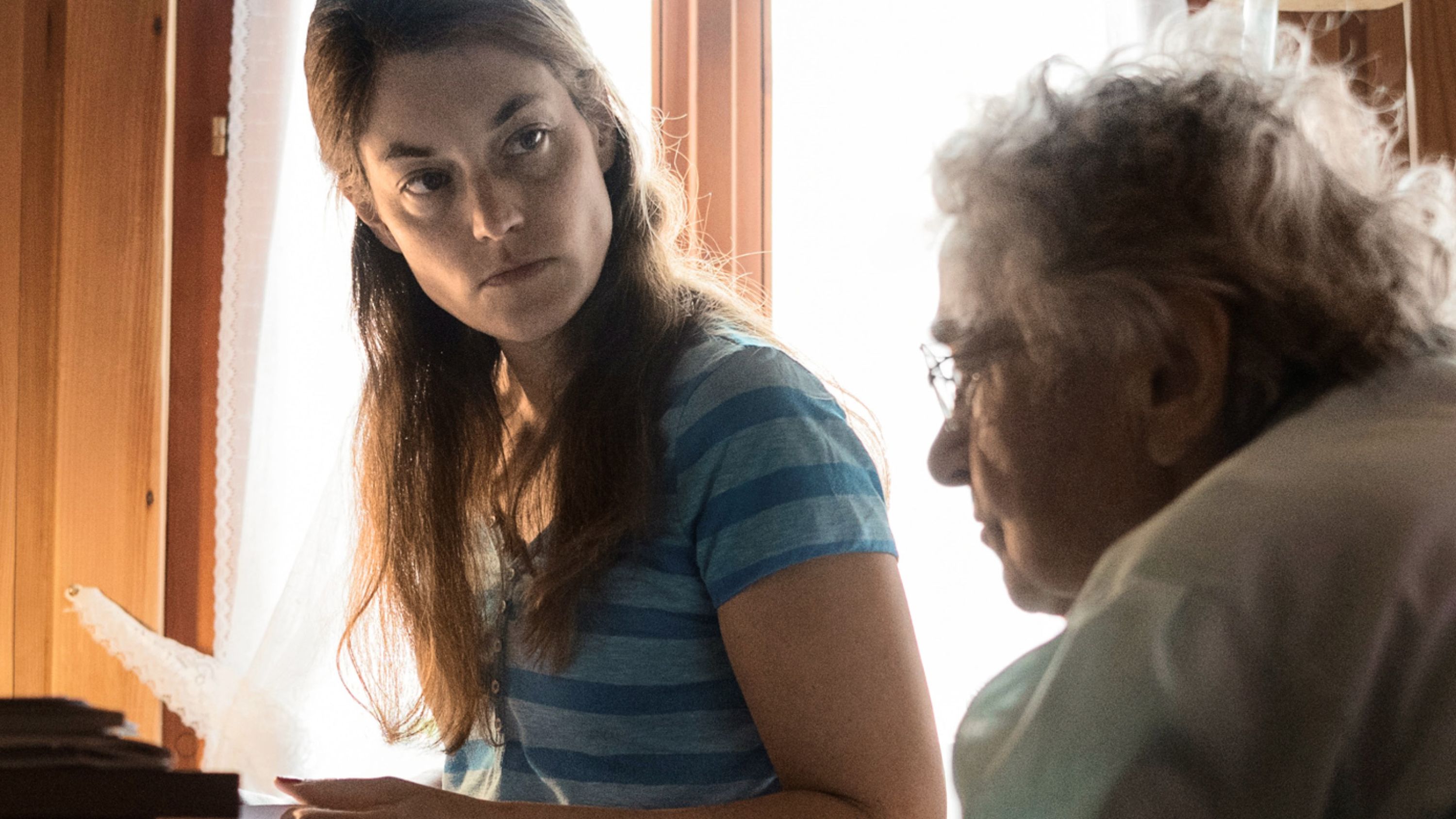 Una donna guarda con aria seria una signora anziana.