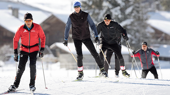 Eine Gruppe Senioren beim Langlaufen in schönster Winterkulisse.