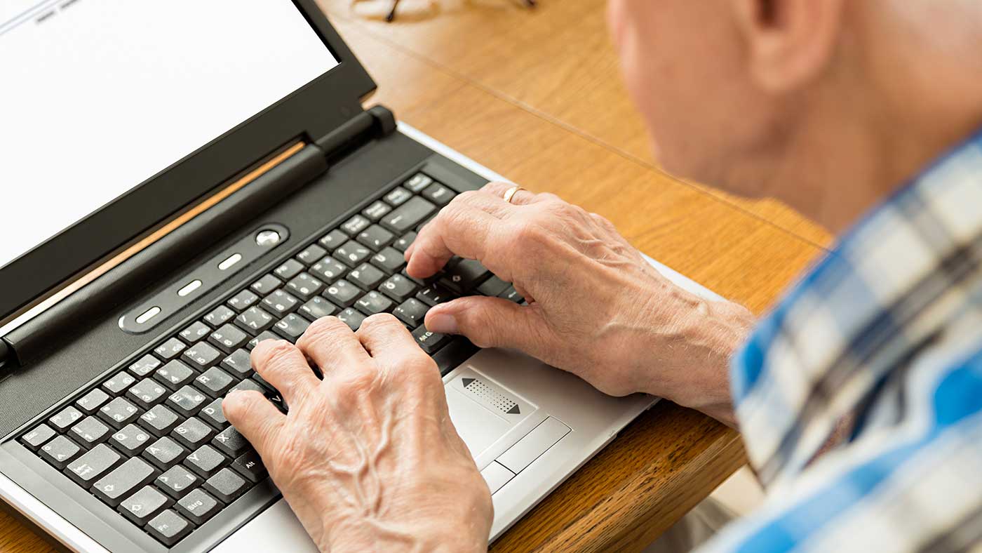 Senior bedient Tastatur von Laptop