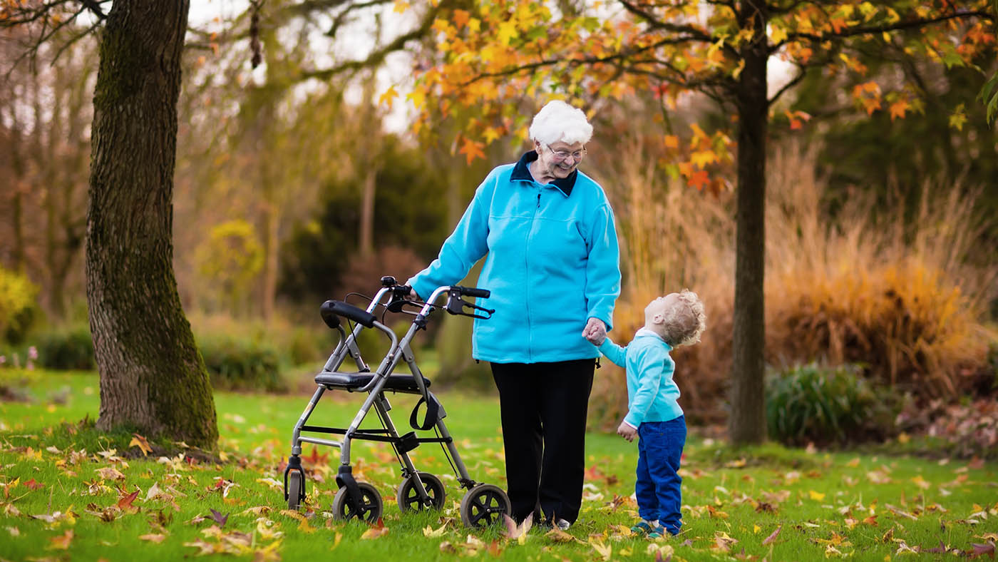 Eine ältere Frau ist geht ihrem Enkel spazieren