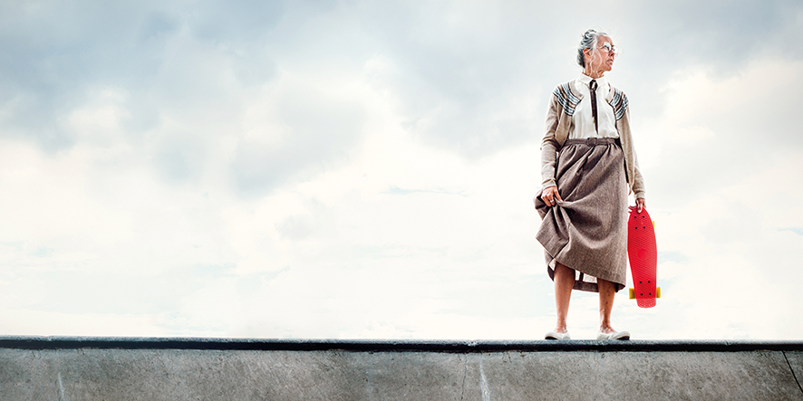 Seniorin mit Skateboard am Rand der Halfpipe